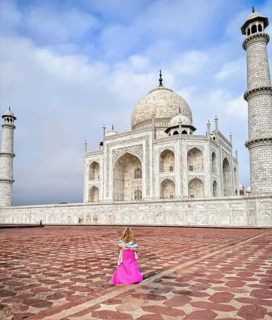 Charity in a pink dress walking toward the Taj Mahal in Agra, India