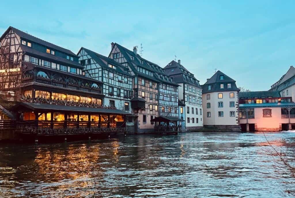 Half-timbered houses glowing at dusk along the canal in La Petite France, Strasbourg, France