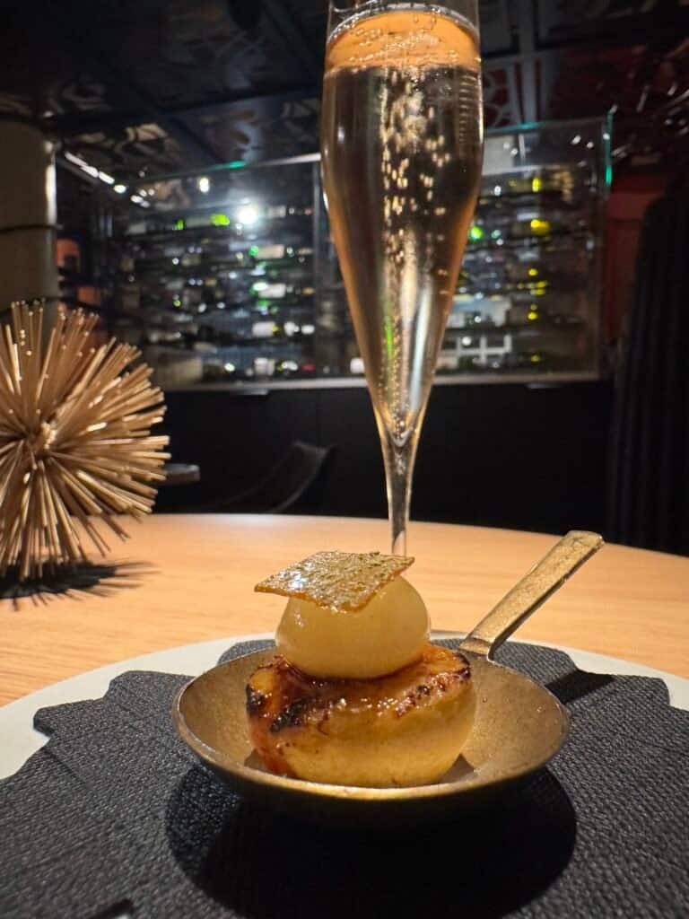 Champagne flute with bruleed amuse-bouche and gold spork at Clairefontaine Luxembourg