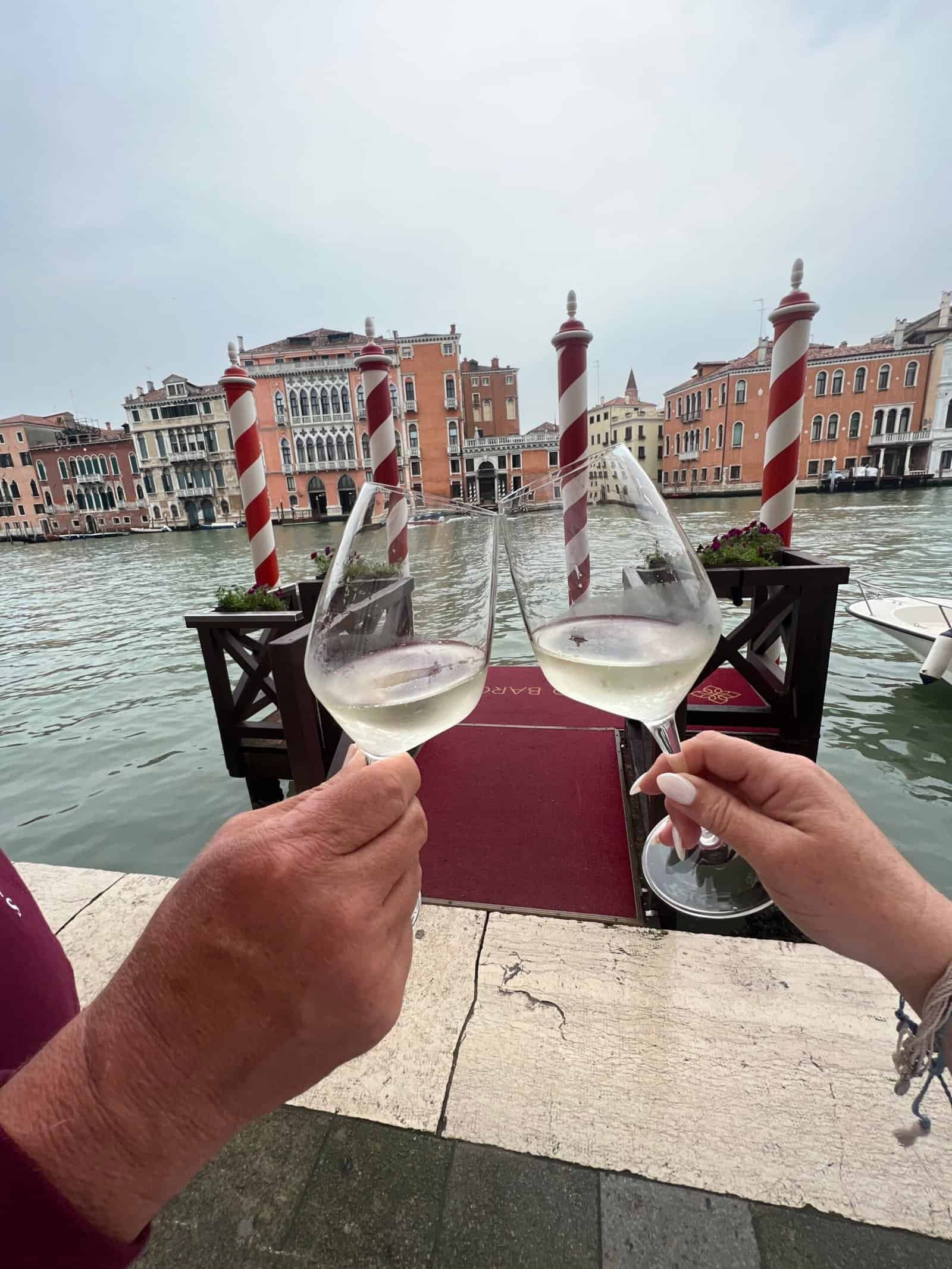 Toasting two glasses of white wine over the Grand Canal in Venice, Italy