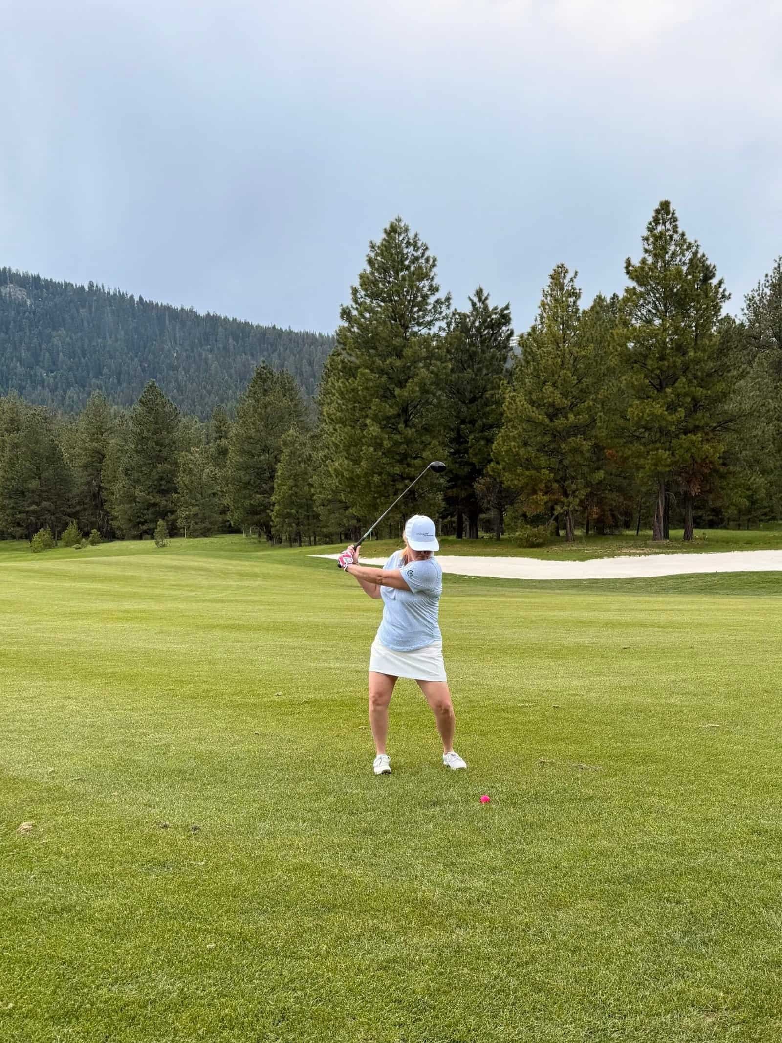 Charity mid golf swing at Osprey Meadows golf course, Tamarack Resort, Idaho