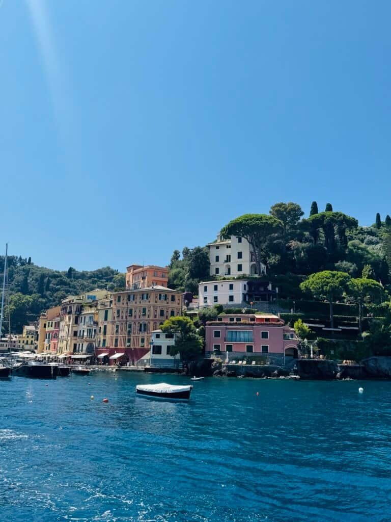 The pastel harbor houses of Portofino rising above the turquoise Ligurian Sea, Italy