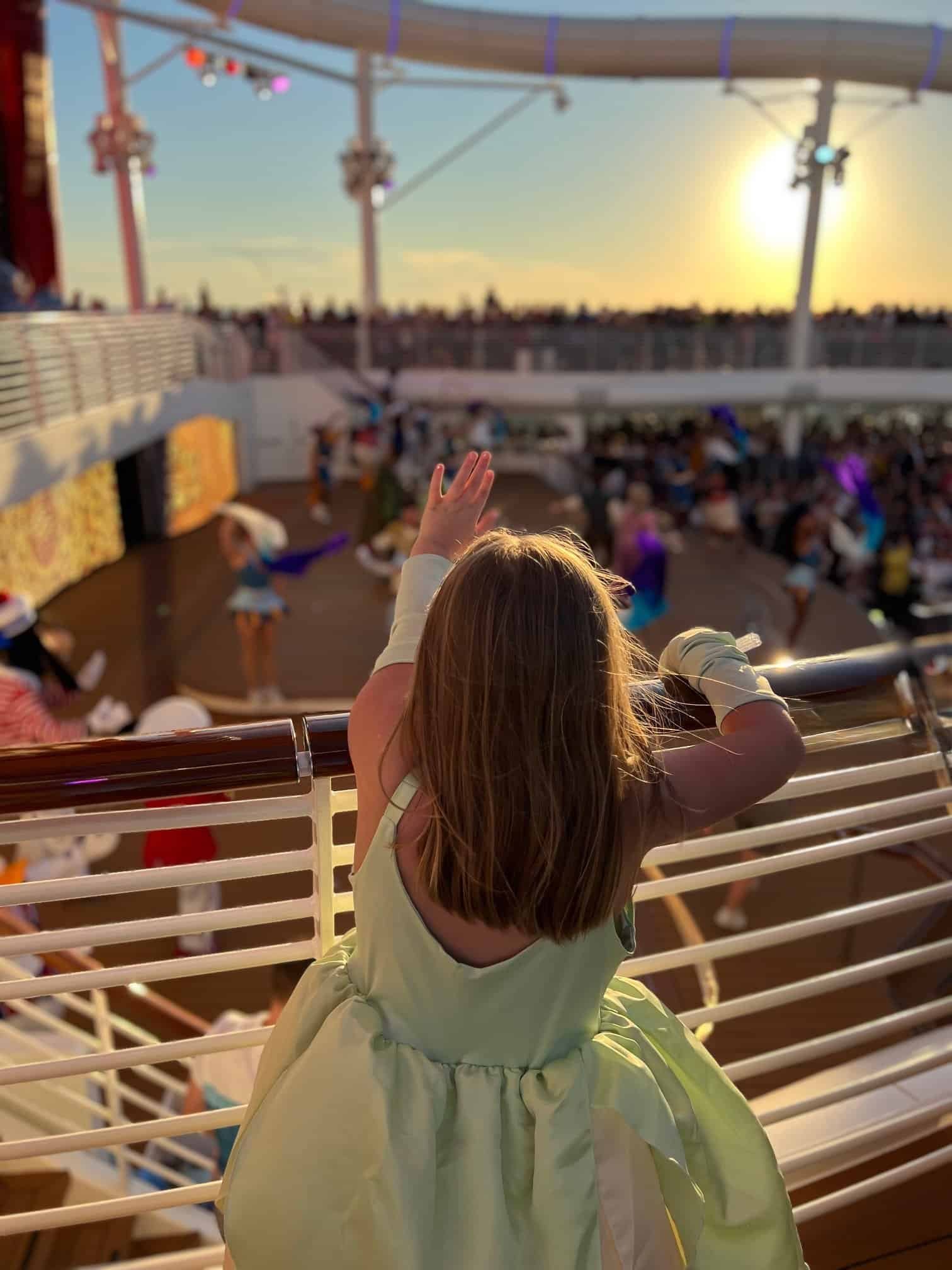 Charlie in the green gown waving at golden hour