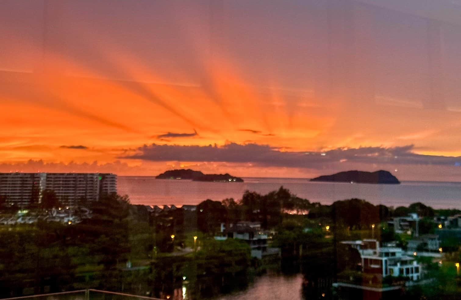 A fiery orange sunset over the sea and islands seen from the Marriott lounge in Kota Kinabalu, Borneo.